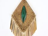 une image représentant un pendentif doré et vert sur fond blanc
