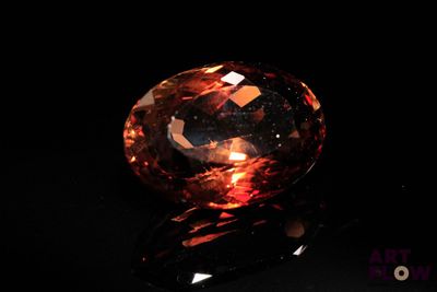 un losange orange sur une surface noire, avec un fond noir
