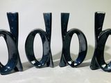 trois vases noirs posés les uns à côté des autres sur une table