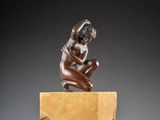 an image of a bronze statue of a woman kneeling on a block