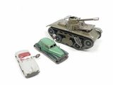 two toy cars and a toy tank on a white surface