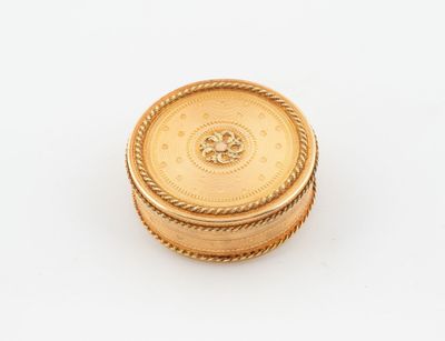 une boîte plaquée or dont le couvercle est orné d'un motif circulaire