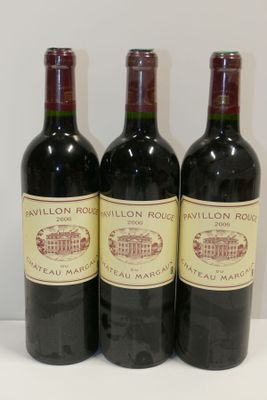 trois bouteilles de vin rouge sont alignées sur une table