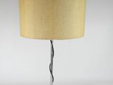 a black table lamp with a beige shade on top of it