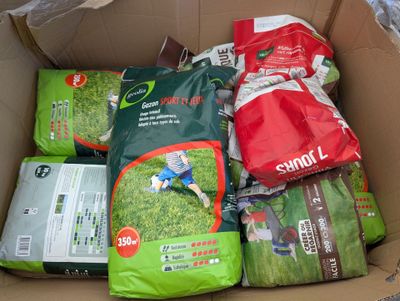 a cardboard box filled with various types of gardening supplies