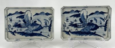 pair of blue and white plates with a bird and a dragon on them