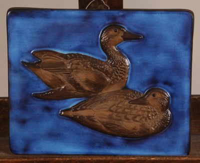 two ducks that are sitting on a blue tile