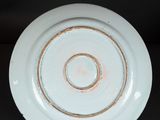 a white plate with a brown rim on a black background