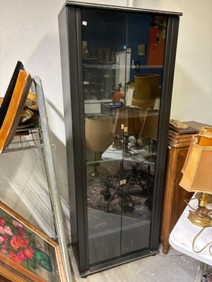 une vitrine sur laquelle est accrochée une peinture, dans une pièce