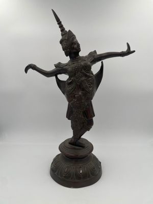 a bronze statue of a woman holding a bird on a pedestal