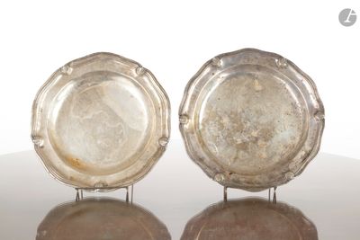 paire de plats en argent posés sur un support, sur une surface réfléchissante avec un fond blanc