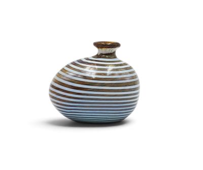 a blue and white striped vase sitting on a white surface