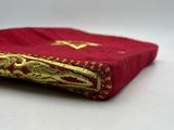 a close up of a red book with gold trim