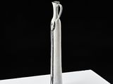 a silver vase that is sitting on a white table