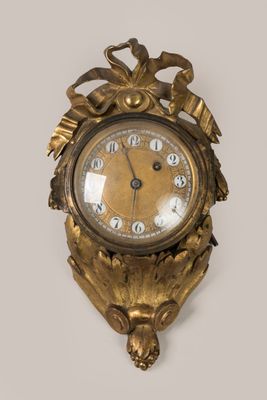 a gold clock on the wall with a bird on it