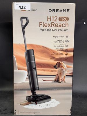 the box of a vacuum cleaner with a dog sitting on the floor