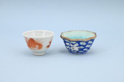 une paire de petits bols bleus et blancs ornés de fleurs orange