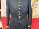 un manteau militaire noir à boutons dorés, posé sur un présentoir pour mannequin