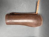 a brown leather case with a wooden handle on a table