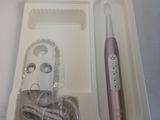 a white box with a pink electric toothbrush in it