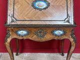 un bureau ancien doté d'un plateau en bois et de sculptures ornées