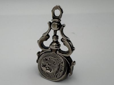 an old silver pocket watch with a chain hanging from it ' s side