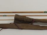 three fishing rods and a fishing pole on a white surface