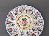 une assiette blanche ornée de motifs rouges et verts