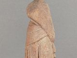 une vieille statue représentant une femme avec un châle sur la tête