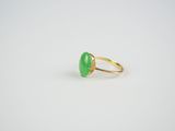a gold ring with a green jade stone in the middle