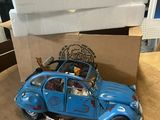 a blue toy car sitting on a table next to a cardboard box