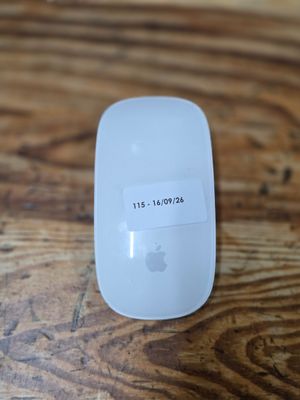 a white apple mouse sitting on top of a wooden table