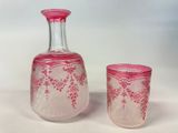 pair of pink glass vases sitting next to each other on a white surface
