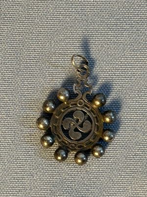 une photo d'un pendentif sur lequel figure une horloge