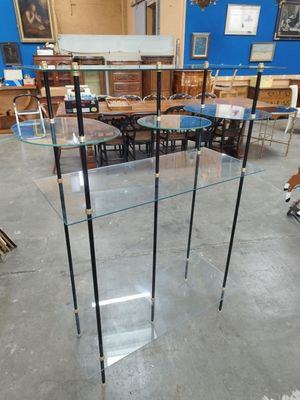 une table en verre sur laquelle sont posées trois étagères en verre