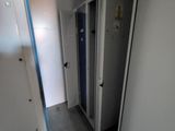 a long hallway with two doors and a mirror on the wall