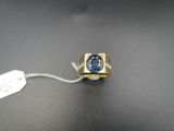 Gros plan sur une bague en or ornée d'une topaze bleue