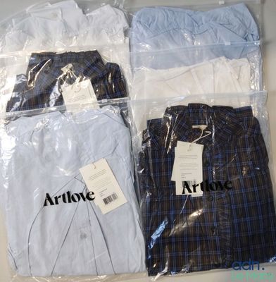 three pairs of men ' s shirts in plastic bags on a table
