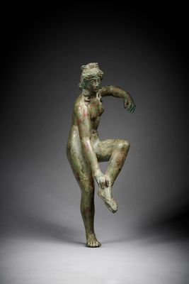 a bronze statue of a man sitting on his knees