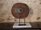 une sculpture en bois posée sur une table devant un mur de pierre