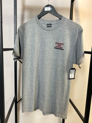 un t-shirt gris suspendu à un portant dans un magasin de vêtements