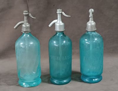 three blue glass bottles with soap dispensers on them