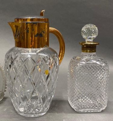 a glass pitcher and a glass bottle next to each other