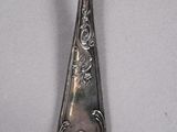 a silver spoon with a floral design on it