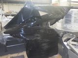 a large pile of black plastic bags on a pallet