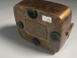 a small metal box with buttons on it on a white surface