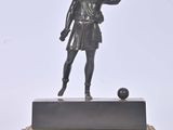 figurine en bronze représentant un homme tenant une balle, posée sur un socle en marbre
