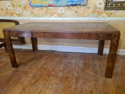a wooden table with a wooden chair in the corner of the room