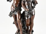 une statue antique en bronze représentant deux chérubins, posée sur un socle en marbre