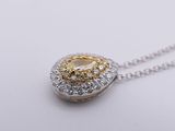 a close up of a yellow and white diamond pendant on a chain